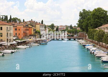 PESCHIERA DEL GARDA, ITALIEN - 9. JUNI 2020: Schöne historische Innenstadt mit Promenade und Unterhaltung entlang des Wasserkanals am Gardasee, Ital Stockfoto