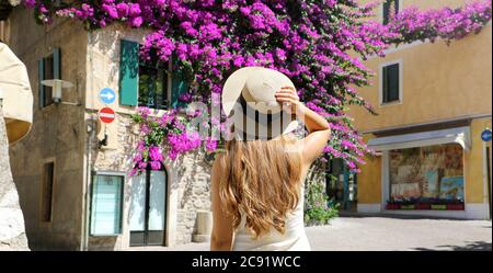 Rückansicht der jungen Touristen Frau mit Hut Besuch Sirmione alten blühenden Stadt am Gardasee, Italien Stockfoto