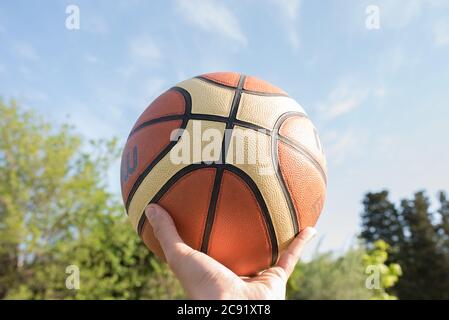 Mann, der einen Basketballball in einer Hand hält Stockfoto