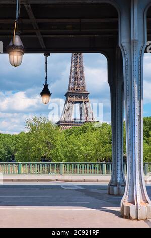 Paris, historische Metallbrücke Pont de Bir-Hakeim über seine mit Teilblick auf den Eiffelturm an einem sonnigen Tag mit Tageslicht, blauem Himmel und Wolken Stockfoto
