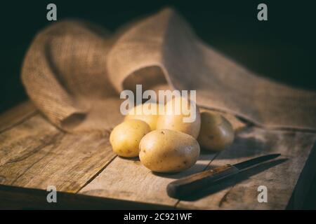 Kartoffeln auf schwarzem Hintergrund, Kartoffeln auf einem Holztisch Stockfoto