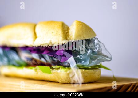 Hotdog gefüllt mit Plastikmüll und Papierkarton. Recycelter Abfall in unserem Lebensmittelkonzept Stockfoto