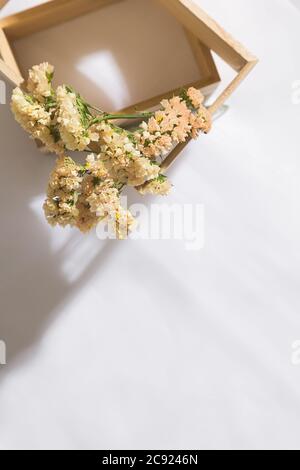 Draufsicht auf eine hölzerne Nische im Voile Stoff Hintergrund mit Blumen, mit Platz für Text Stockfoto