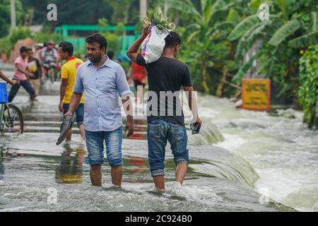 Munshiganj, Bangladesch. Juli 2020. In Sreenagar in Munshiganj bei Dhaka laufen Menschen durch Hochwasser.ein Drittel von Bangladesch ist unter Wasser, nachdem einige der schwersten Regenfälle seit einem Jahrzehnt und mehr als 3 Millionen Menschen mit Häusern und Straßen in Dörfern überflutet wurden, Beamte des Hochwasserprognosen- und Warnzentrums (FFWC) haben dies gesagt. Die Überschwemmungssituation in 20 nördlichen und zentralen Bezirken aufgrund des Anstiegs des Wasserstockels der Hauptflüsse, einschließlich der Brahmaputra, Jamuna, Padma, Teesta und Dharla. Kredit: SOPA Images Limited/Alamy Live Nachrichten Stockfoto