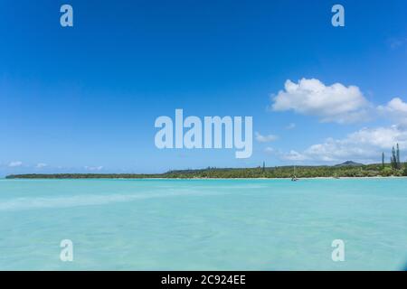 Wunderschöne Seeslandschaft der UPI Bay, Pines Island, neukaledonien: Türkisfarbene Lagune, üppige Vegetation, blauer Himmel Stockfoto