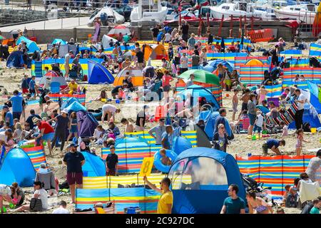 Lyme Regis, Dorset, Großbritannien. Juli 2020. Wetter in Großbritannien. Der Strand ist voll, als Urlauber und Sonnenanbeter strömen in den Badeort Lyme Regis in Dorset an einem Tag der heißen Sonneneinflucht. Bildquelle: Graham Hunt/Alamy Live News Stockfoto