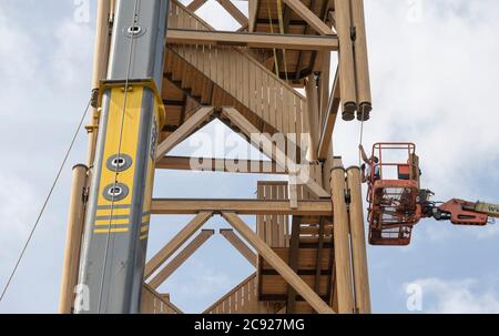 28. Juli 2020, Hessen, Frankfurt/Main: Mit Hilfe eines Krans wird das letzte von insgesamt drei Segmenten des Frankfurter Goetheturms in seine Position gehoben. Der Neubau war notwendig geworden, nachdem der alte Goeteturm Opfer von Brandstiftung geworden war. Foto: Boris Roessler/dpa Stockfoto