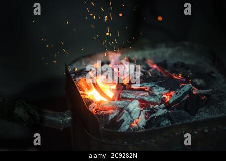 Leere heiße Holzkohle Barbecue-Grill mit hellen Flamme auf dem schwarzen Hintergrund Stockfoto