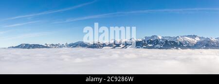 Fantastischer Panoramablick auf die Schneebergkette ragt aus der Inversionsnebelschicht heraus. Tolles Panorama mit sonnigem blauen Himmel über den Wolken. Ofterschwanger Stockfoto