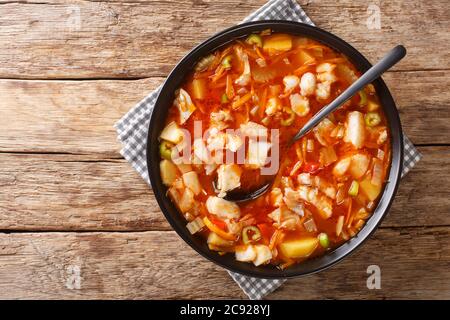 Bermudafischtomatensuppe mit saisonalem Gemüse und schwarzem Rum in einer Schüssel auf dem Tisch. Horizontale Draufsicht von oben Stockfoto