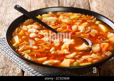 Bermudafischtomatensuppe mit saisonalem Gemüse und schwarzem Rum in einer Schüssel auf dem Tisch. Horizontal Stockfoto