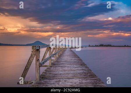 Alte hölzerne Werft mit langer Belichtung während des Sonnenuntergangs geschossen. Lage ist Tokaanu Wharf in Taupo Region North Island, Neuseeland. Stockfoto