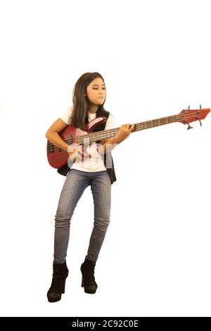 Ein süßes asiatisches Mädchen mit langen Haaren spielt fröhlich rote E-Bass-Gitarre. Ein isoliertes Bild mit weißem Hintergrund Stockfoto