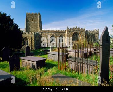 St. Beuno's Kirche und seine freistehende C16. Schreinkapelle, Bedd Beuno, Clynnog Fawr, Wales. Viktorianische Schiefergräber und Grabsteine im Vordergrund. Stockfoto