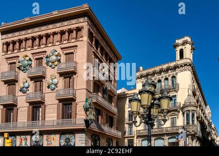 Chinesische Drachen Skulptur an den Wänden eines Hauses mit Sonnenschirmen, Bruno Quadras Gebäude, Las Ramblas, Barcelona Stockfoto