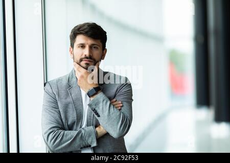 Geschäftsmann posiert zuversichtlich und positiv in professionellen Arbeitsplatz Büro mit Platz Stockfoto