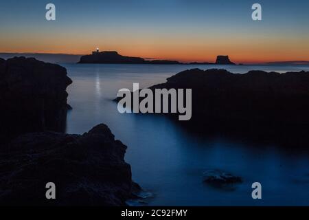 Ein Sonnenaufgang am frühen Morgen wird über der Festung der Einsamkeit Strand von Fidra Leuchtturm in East Lothian gesehen, wie Schottland ist in der 7. Woche der Lockdown d Stockfoto