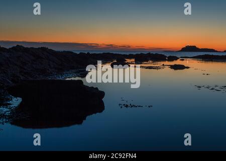 Ein Sonnenaufgang am frühen Morgen wird über der Festung der Einsamkeit Strand von Fidra Leuchtturm in East Lothian gesehen, wie Schottland ist in der 7. Woche der Lockdown d Stockfoto