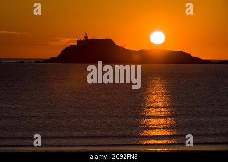 Ein Sonnenaufgang am frühen Morgen wird über der Festung der Einsamkeit Strand von Fidra Leuchtturm in East Lothian gesehen, wie Schottland ist in der 7. Woche der Lockdown d Stockfoto