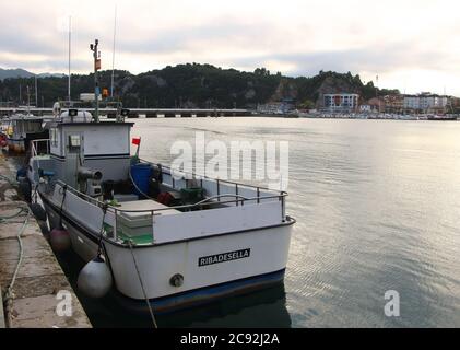 Abendlicht mit einem festgetäuten Fischerboot mit der Brücke über den Fluss Sella in Ribadesella Asturias Spanien Stockfoto