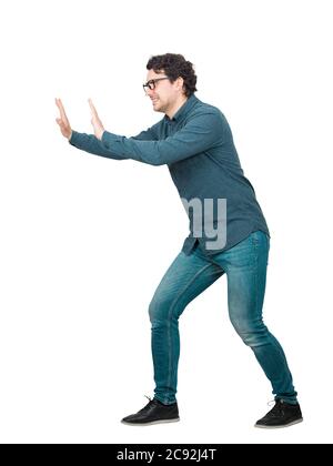 Entschlossener Geschäftsmann macht Mühe schieben ein schweres unsichtbares Objekt isoliert auf weißem Hintergrund. Selbstbewusste Person, schwieriges Aufgabenkonzept, überzeugen Stockfoto