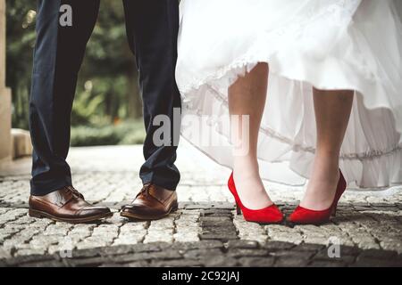 Die Beine der Braut und des Bräutigams sind nach innen gebogen. Lustig und konzeptuell. Stockfoto