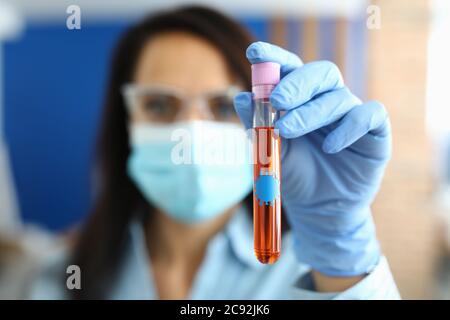 Arzt in Handschuhen hält Reagenzglas mit covid 19 Virus. Stockfoto