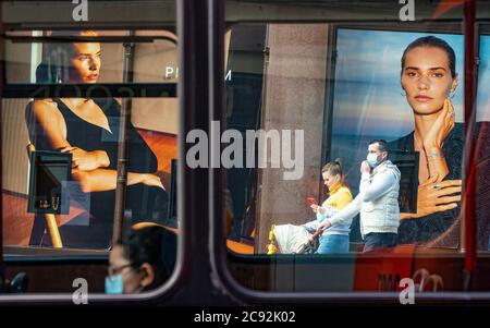 Edinburgh, Schottland, Großbritannien. Juli 2020. 28 Business und Tourismus langsam wieder in die Geschäfte und Straßen von Edinburgh Stadtzentrum. Blick durch Busfenster von Werbetafeln in Fenstern des Jeners Kaufhauses auf der Princes Street mit Mitgliedern der Öffentlichkeit, die Gesichtsmasken tragen. Iain Masterton/Alamy Live News Stockfoto