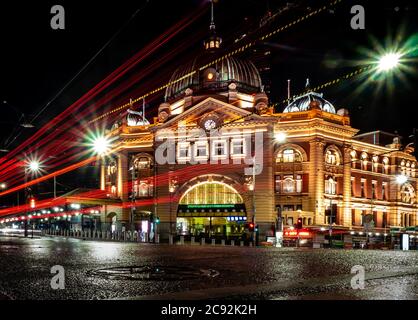 Straßenbahnen und Autos vor der berühmten melbourne Flinders Street Station sind von Lichtern durchleuchtet Stockfoto