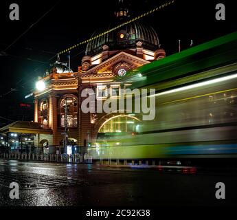 Straßenbahnen und Autos vor der berühmten melbourne Flinders Street Station sind von Lichtern durchleuchtet Stockfoto