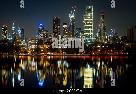 Die Spiegelungen der skyline von melbourne in der Abenddämmerung im stillen Wasser des albert Park Lake Stockfoto