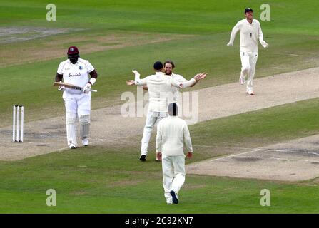 Der englische Chris Woakes (Mitte) feiert das Bestehen des Dickens von Rahkeem Cornwall von West Indies (links) am fünften Tag des dritten Tests im Emirates Old Trafford, Manchester. Stockfoto