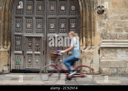 Studentin Reiten Altmodisches Fahrrad Um Oxford University College Gebäude Mit Bewegungsunschärfe Stockfoto