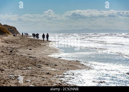 Die Menschen wurden am Strand von Formby, Formby, Merseyside geschilhoutet. Stockfoto