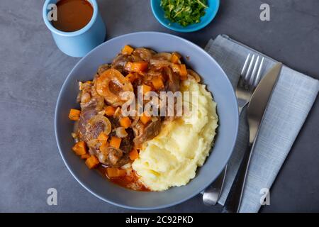 Ossobuco. Kalbsbretter mit Kartoffelpüree, Gremolata und Sauce. Traditionelles italienisches Gericht. Nahaufnahme. Stockfoto