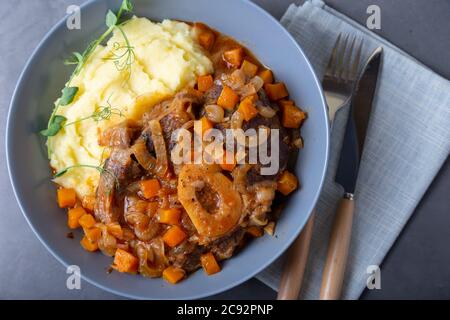 Ossobuco. Kalbsbretter mit Kartoffelpüree, Gremolata und Sauce. Traditionelles italienisches Gericht. Nahaufnahme. Stockfoto