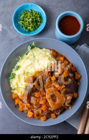 Ossobuco. Kalbsbretter mit Kartoffelpüree, Gremolata und Sauce. Traditionelles italienisches Gericht. Nahaufnahme. Stockfoto