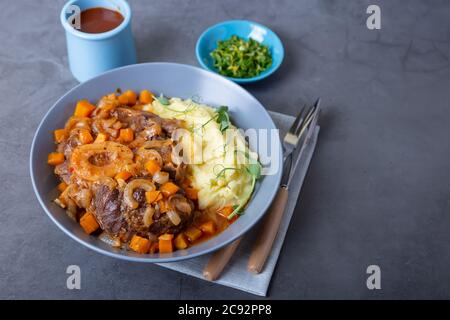 Ossobuco. Kalbsbretter mit Kartoffelpüree, Gremolata und Sauce. Traditionelles italienisches Gericht. Nahaufnahme. Stockfoto