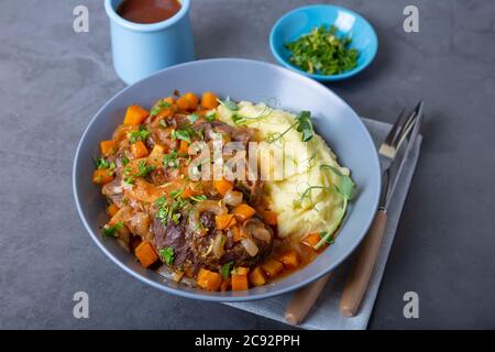 Ossobuco. Kalbsbretter mit Kartoffelpüree, Gremolata und Sauce. Traditionelles italienisches Gericht. Nahaufnahme. Stockfoto