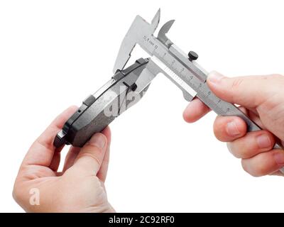 Bremsbeläge des Kfz-Ersatzteiles auf weißem Hintergrund, Messung durch einen Bremssattel der Dicke auf der Hand des Ingenieurs. Stockfoto
