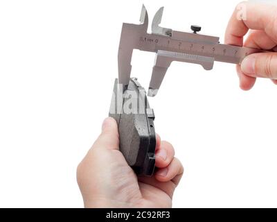 Bremsbeläge des Kfz-Ersatzteiles auf weißem Hintergrund, Messung durch einen Bremssattel der Dicke auf der Hand des Ingenieurs. Stockfoto