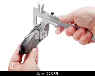 Bremsbeläge des Kfz-Ersatzteiles auf weißem Hintergrund, Messung durch einen Bremssattel der Dicke auf der Hand des Ingenieurs. Stockfoto