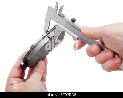 Bremsbeläge des Kfz-Ersatzteiles auf weißem Hintergrund, Messung durch einen Bremssattel der Dicke auf der Hand des Ingenieurs. Stockfoto