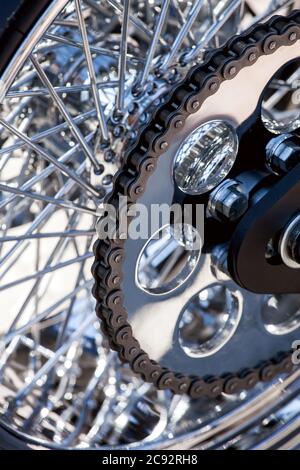 Motorrad Kette auf einem Hinterrad mit verchromten Speichen, deteil Motorrad Teil. Stockfoto