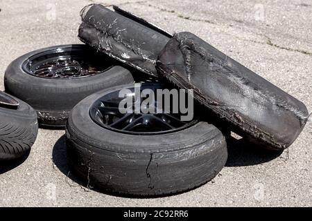 Ein Haufen Räder liegt auf dem Asphalt und wird nach dem Abdriften zum Schreddern von Reifen verwendet. Stockfoto