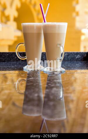 Zwei Gläser Frappe mit Stroh auf einer Marmorplatte mit Spiegelung, ein kühlender Kaffeecocktail für ein Paar. Stockfoto