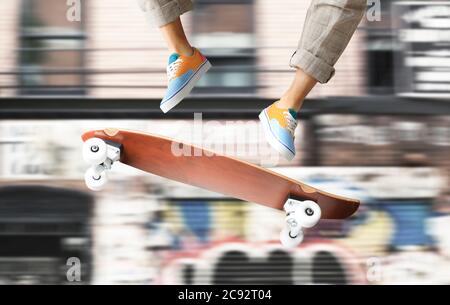 Skateboarder in farbigen Sneakers springen auf einem Skateboard Stockfoto