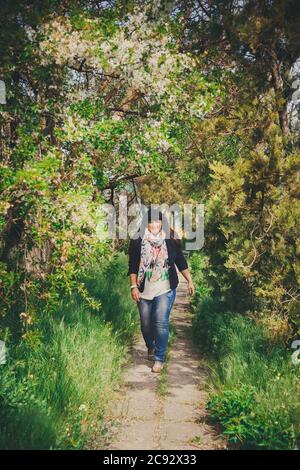 Glücklich lächelnd schöne übergewichtige junge Frau in dunkelblauer Jacke und Schal mit Anker zu Fuß im Freien. Selbstbewusst Fett junge Frau. XXL-Frau, plus Stockfoto