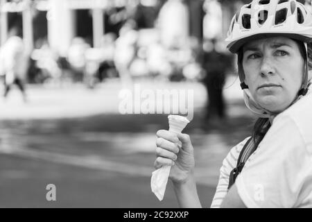 Frau in einer Straße mit Fahrradhelm und Eis draußen, York, North Yorkshire, England, Vereinigtes Königreich. Stockfoto
