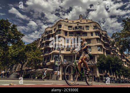 Barcelona, Spanien. Juli 2020. Ein Fahrradfahrer mit einer schützenden Gesichtsmaske passiert Gaudis 'La Pedrera', als Deutschland seine Reiseempfehlungen für drei spanische Regionen einschließlich Barcelona inmitten eines neuen Ansteckens von Coronavirus-Fällen aktualisiert. Quelle: Matthias Oesterle/Alamy Live News Stockfoto